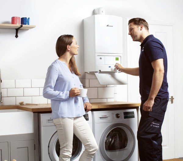 Engineer explaining boiler controls to a homeowner